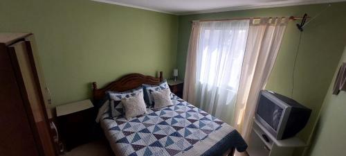 a bedroom with a bed with pillows and a tv at casa villa costa de sol, calderilla in Calderilla