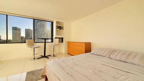 ein Schlafzimmer mit einem Bett und einem großen Fenster in der Unterkunft Waikiki beach cozy studio no resort fee in Honolulu