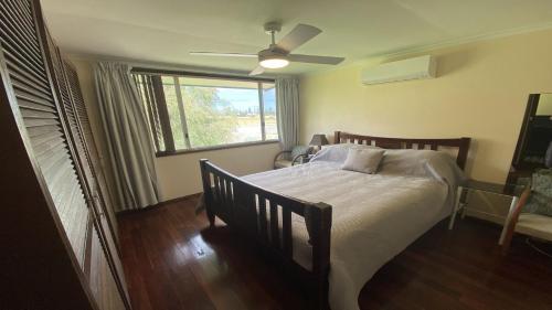 Un dormitorio con una cama con ventilador de techo y una ventana. en Eleven, en Jurien Bay