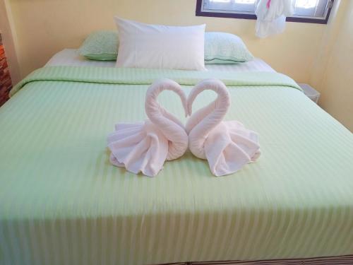 two pink swans forming a heart on a bed at Wandee Resort Bankrut in Ban Krut