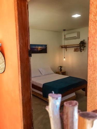 un dormitorio con una cama en una habitación en Tatu Suítes, en Porto de Pedras
