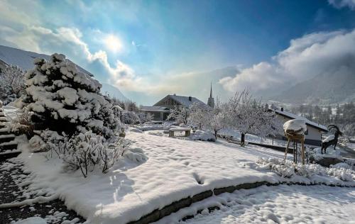a snow covered yard with a snow covered tree at Waldchalet Steinbock in Sankt Anton im Montafon