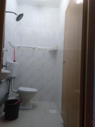 a white bathroom with a toilet and a sink at Layya Homestay in Pasir Mas