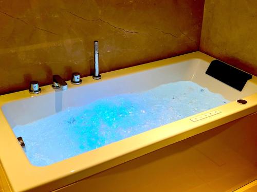 una bañera amarilla con agua azul. en Planet Hollywood Thane, en Thane