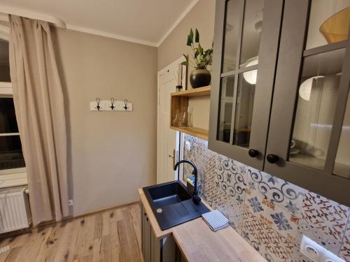 a kitchen with a blue sink and a window at Klimatyczny Apartament na Bydgoskim Przedmieściu in Toruń