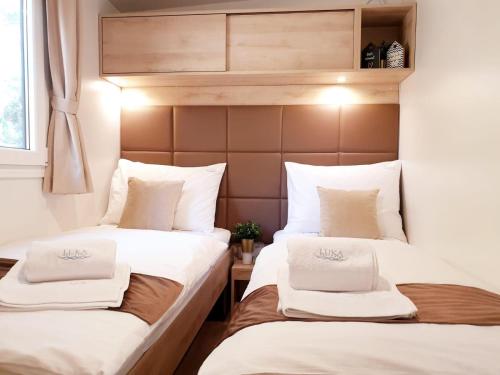 2 łóżka w małym pokoju z białymi poduszkami w obiekcie Sandra Holiday Homes w Biogradzie na Moru
