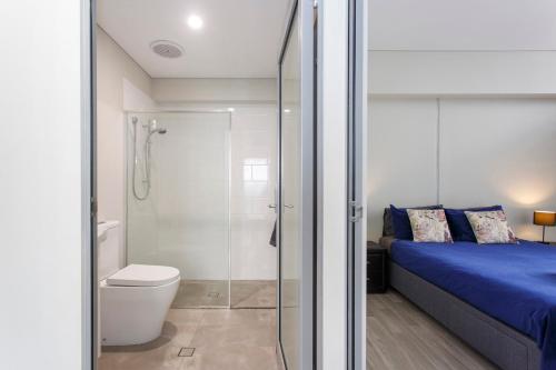 baño con ducha, cama y aseo en Waverley apartment F-two bedrooms wifi available, en Perth