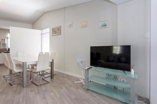 a living room with a television and a table with chairs at Waverley apartment F-two bedrooms wifi available in Perth