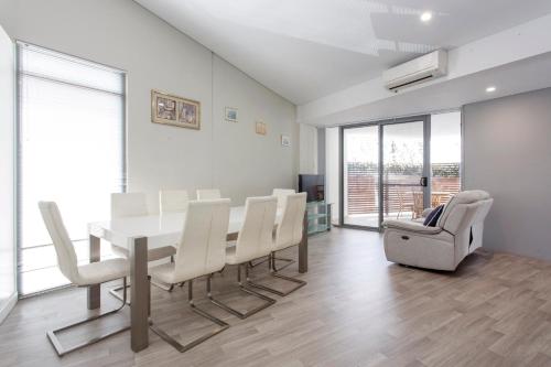 a dining room with a table and white chairs at Waverley apartment F-two bedrooms wifi available in Perth