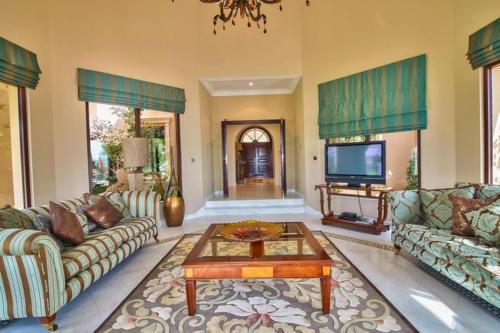 a living room with couches and a coffee table at Palm's Largest Beachfront Estate in Dubai