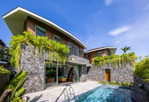 a house with a swimming pool in front of it at Bellerive Hoi An Resort and Spa in Hoi An