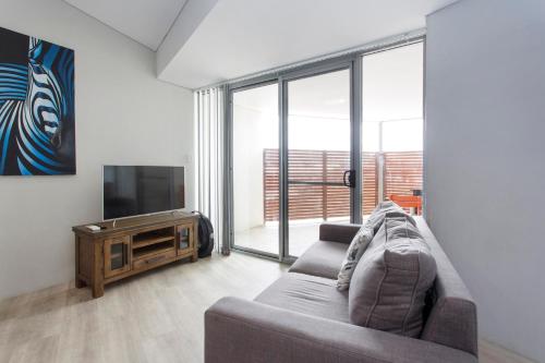 a living room with a couch and a television at Waverley apartment C-one bedroom wifi available in Perth