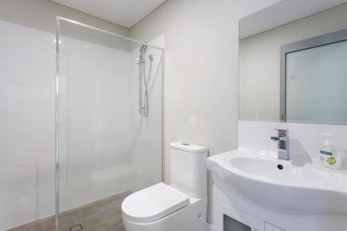 Baño blanco con aseo y lavamanos en Waverley apartment B-one bedroom wifi available en Perth