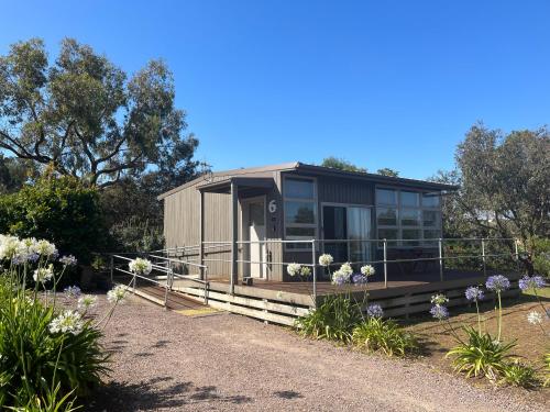 a tiny house in a garden with flowers at Harmony at Tower Hill in Koroit