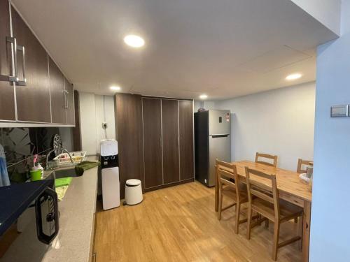 a kitchen with a table and chairs and a refrigerator at Illusyin Retreat in Shah Alam