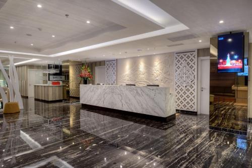 a lobby with a reception desk in a building at Platinum Adisucipto Hotel & Conference Center in Yogyakarta