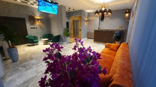 a living room with a couch and purple flowers at TALLES CITY HOTEL in Konak