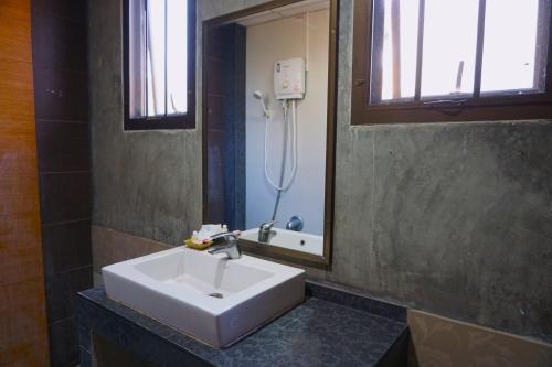 een witte wastafel in een badkamer met een spiegel bij Tamnak Lanta @Chiang Mai in Chiang Mai