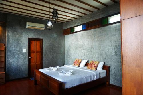 1 dormitorio con 1 cama grande con sábanas blancas en Tamnak Lanta @Chiang Mai, en Chiang Mai