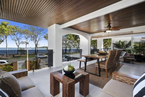 a living room with a table and a view of the ocean at 'The Beach House' in Bongaree