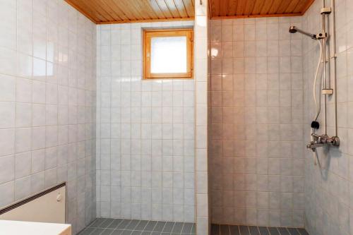 La salle de bains est pourvue d'une douche avec du carrelage blanc. dans l'établissement Holiday Home - Detached house 108m2, 3 rooms, 1 living room, Sauna, à Joensuu