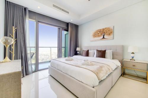 um quarto com uma cama grande e uma janela grande em Primestay - Paramount Midtown 1BR in Business Bay em Dubai
