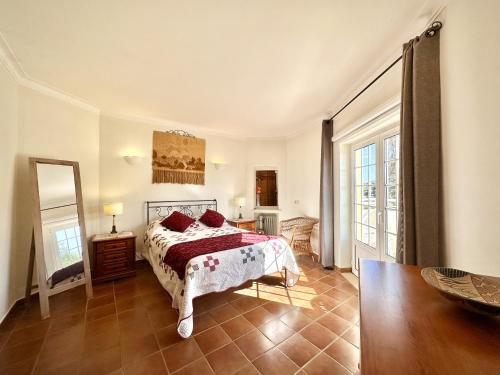 本薩夫林的住宿－Casa da Aldeia，一间卧室配有一张床和镜子