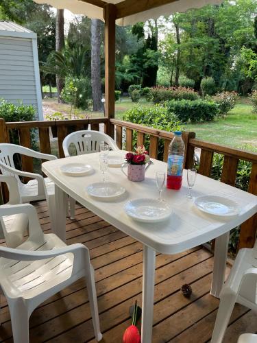 une table et des chaises blanches sur une terrasse dans l'établissement Mobil Home Camping ARGELÈS SUR MER, à Argelès-sur-Mer