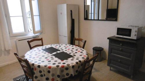 a kitchen with a table with a polka dot table cloth at Appartement LE COURS in Barbentane