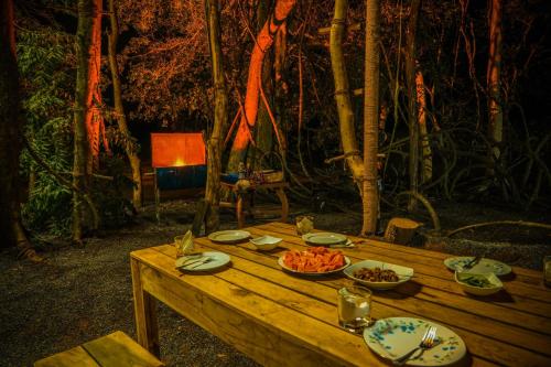 a wooden table with plates of food on it at Eco Bliss Cottages - Thanamalwila in Nikawewa
