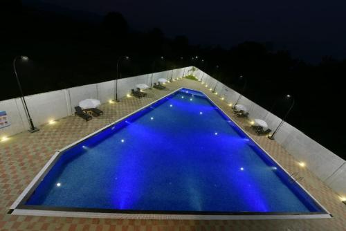 a large blue pool on a patio at night at Wandr Zen in Khopoli