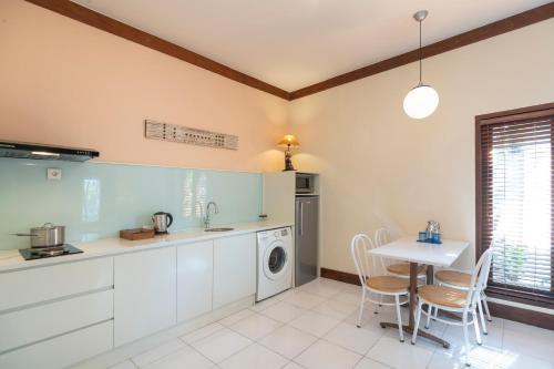 a kitchen with a table and a washing machine at Rama Residence Petitenget in Seminyak
