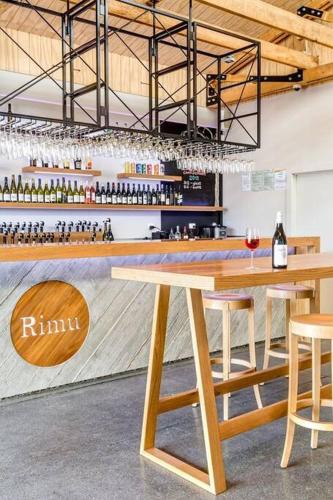a bar with a wooden table and some bottles of wine at Ruby Bay Loft Accommodation in Nelson