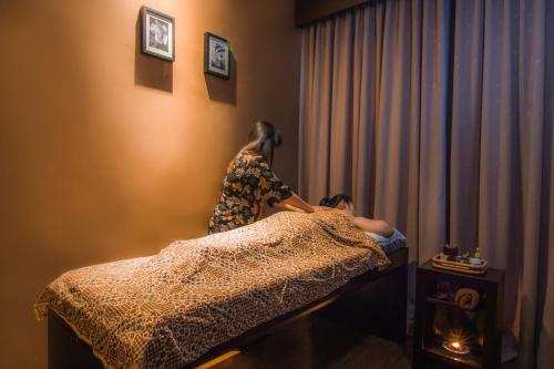 a woman and a girl sitting on a bed at Swiss-Belinn Baloi Batam in Nagoya