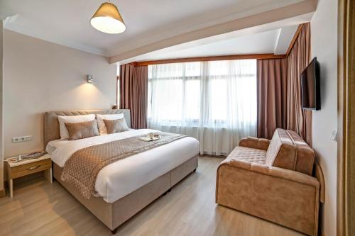 een hotelkamer met een groot bed en een stoel bij SEVEN ROSES APART HOTEL in Istanbul