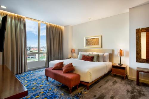 a hotel room with a bed and a large window at Jambuluwuk Malioboro Hotel Yogyakarta in Yogyakarta