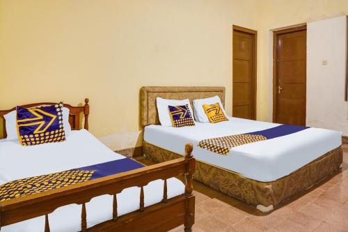 dos camas sentadas una al lado de la otra en una habitación en OYO Life 92087 Griya Nurainy, en Pasuruan
