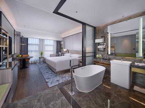 ein Hotelzimmer mit einem Bett und einer Badewanne in der Unterkunft Doubletree By Hilton Anshan in Anshan