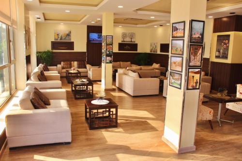 a living room with couches and chairs and tables at Weekdays Hotel in Muscat