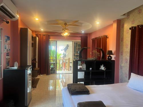 a bedroom with orange walls and a bed and a ceiling at Golf House in Phuket