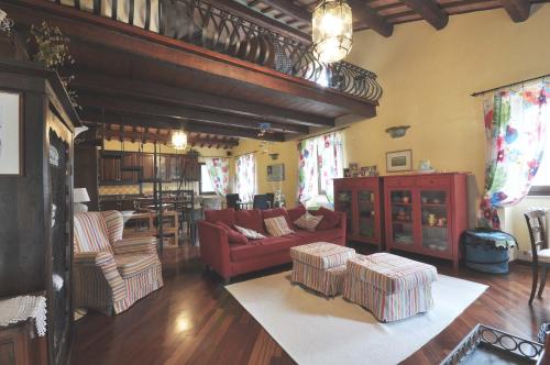 sala de estar con sofá rojo y sillas en Armonia della Sera B&B - Residenza di campagna, en Porto SantʼElpidio