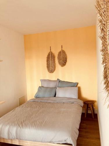 une chambre avec un lit avec des oreillers dessus dans l'établissement Le Bohème Parking Proche Centre, à Châteauroux