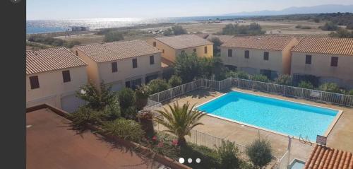 une vue aérienne d'une maison avec piscine dans l'établissement Vue mer splendide studio 3 couchages parking piscine résidence calme, au Barcarès