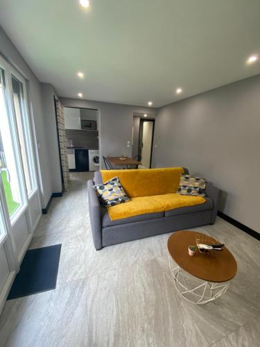 a living room with a yellow couch and a table at Studio standing bord de mer in Mandelieu-La Napoule