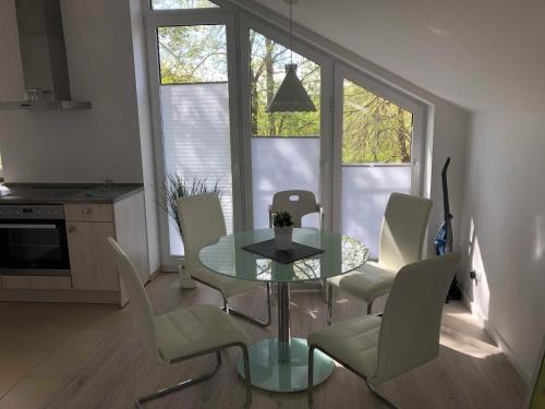 a dining room with a glass table and chairs at Ferienwohnung Völker in Häven