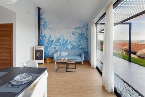 een keuken en een woonkamer met een blauwe muur bij Balcón de Gijón Apartamentos Boutique in Gijón