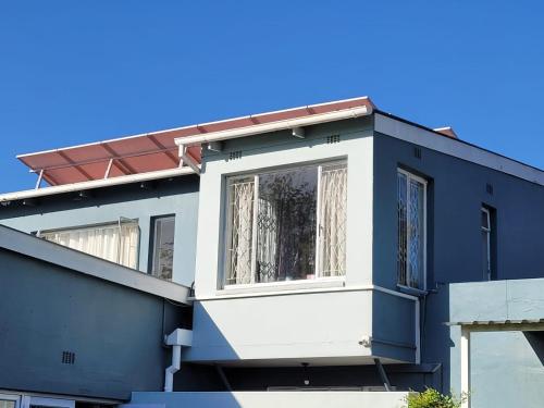 a blue and white house with a window at B&B on Buckingham Guest House in Johannesburg