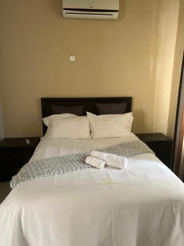 - un lit blanc avec 2 serviettes dans l'établissement Ivwananji I - Kat-Onga Apartments, à Lusaka