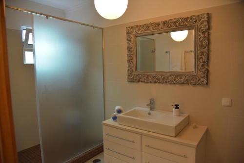 uma casa de banho com um lavatório e um espelho em Quinta do Brasil em Ribeira do Raposo