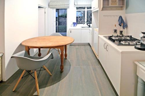 a small kitchen with a wooden table and a chair at B&B on Buckingham Guest House in Johannesburg